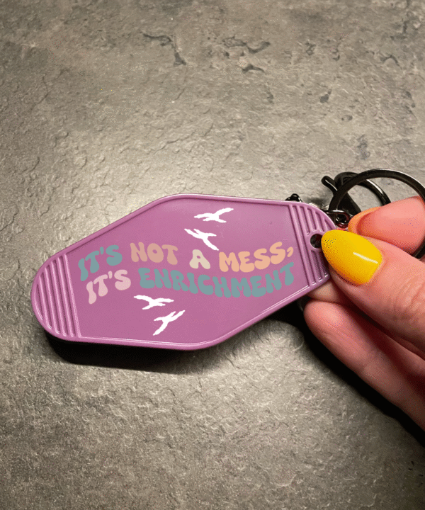 Sleutelhanger met tekst ‘It’s not a mess, it’t enrichment’ – voor papegaaienliefhebbers